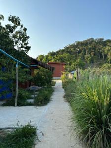 a path leading to a building with a mountain in the background at Maloop Cafe Bungalow in Koh Rong Island