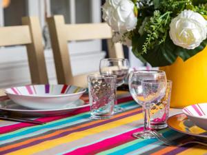 une table avec des assiettes et des verres sur un tissu de table coloré dans l'établissement Maison Les Agapanthes, à Les Sables-dʼOlonne