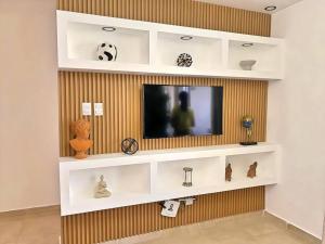 a living room with white shelves and a tv at Apto 3 Habitaciones Zona Tranquila Con Parqueo in Concepción de La Vega