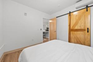 a bedroom with a white bed and a wooden door at Town St Medical Lofts in Columbus