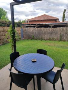 una mesa azul y sillas en un patio en Entre Uvas y Siestas - Casa Sauces en Luján de Cuyo