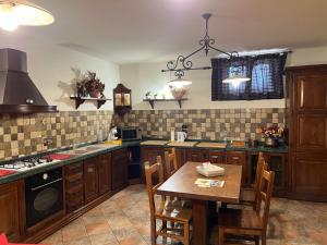 una cucina con armadi in legno e un tavolo in legno con sedie di Assisi, la Noce ad Assisi Altre 66 foto