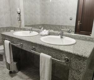 Baño con 2 lavabos y espejo en Motel Punta Cana en Santiago de Compostela