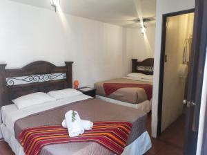 a hotel room with two beds with towels on them at Hotel Casa Nikté in Antigua Guatemala