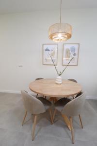 einen Esstisch mit Stühlen und einer Leuchte in der Unterkunft Favara Flats by Concept in Valencia