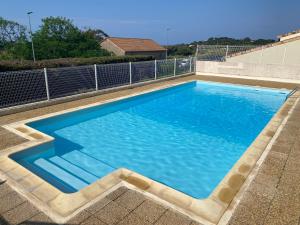 uma grande piscina com água azul em Presqu'île de Giens, Var, La Vue sur le Paradis, Maisonnette 5p av Accès et Jardin PRIVES, Piscine, Plages à 2 min, Face à Porquerolles em Hyères