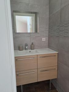 une salle de bain avec un lavabo et un miroir dans l'établissement Le Seventies, à Dunkerque