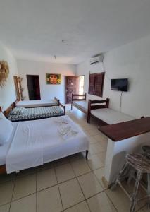 um quarto de hotel com duas camas e uma televisão em Pousada Lua de Jeri em Jericoacoara