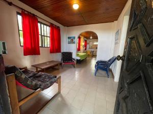sala de estar con cortinas rojas y puerta en Caribbean Queen, en San Andrés