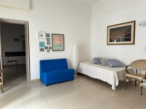 um quarto com uma cadeira azul e uma cama em Peschici a un passo em Peschici