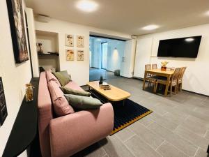 sala de estar con sofá rosa y mesa en Aqua Aura - Deluxe Spa Getaway with Sauna & Pool, en Stegen