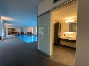 a swimming pool in a building with a kitchen and a bathroom at Aqua Aura - Deluxe Spa Getaway with Sauna & Pool in Stegen