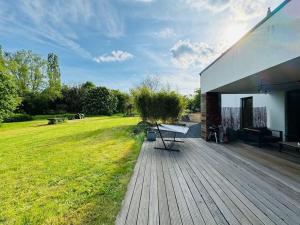 una terraza de madera con un banco en la parte superior de un campo en Aqua Aura - Deluxe Spa Getaway with Sauna & Pool, en Stegen