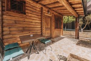 Ethno Lodge AB في فيربازار: كابينة خشبية مع طاولة وكراسي على الفناء