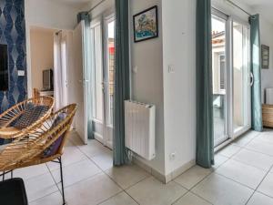 a room with a radiator and chairs and windows at Maison Les Agapanthes in Les Sables-d'Olonne