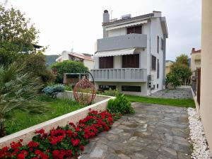 una casa con flores rojas delante de ella en Theros Aegean Villa en Iraklitsa