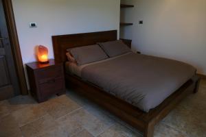 ein Bett mit einem Holzrahmen und einer Lampe auf einem Nachttisch in der Unterkunft Casino del Monaco in Casalvieri