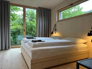 una camera da letto con un letto grande con una grande finestra di Bio Design Appartements DAS GRAUE SCHAF - Kärnten Card im Sommer inklusive a Bad Kleinkirchheim