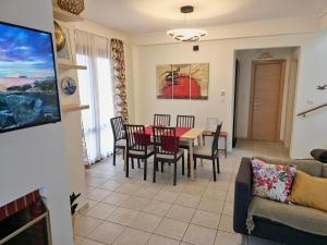 sala de estar con mesa, sillas y sofá en Theros Aegean Villa en Iraklitsa