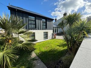 a house with palm trees in front of it at Beach Haven B&B in Tramore