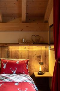 a bedroom with a red bed with a wooden ceiling at Chalet Da Florin in Livigno