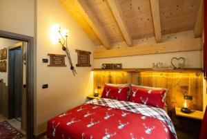 a bedroom with a red bed and wooden ceilings at Chalet Da Florin in Livigno