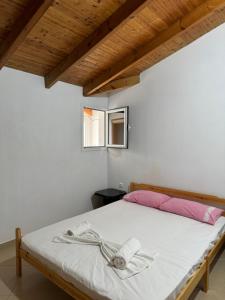 um quarto com uma cama com lençóis brancos e uma janela em L.T. Apartment 5th street em Saranda