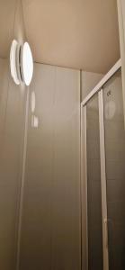 łazienka z prysznicem i lampką na ścianie w obiekcie Appartement confort Clichy JO 2024 w mieście Clichy