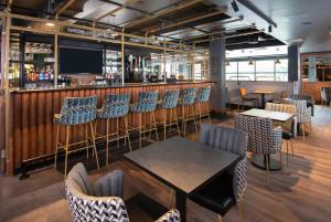 ein Restaurant mit Tischen und Stühlen und eine Bar in der Unterkunft ibis Styles London Gatwick Airport in Crawley