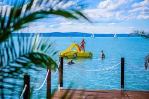 un grupo de personas en el agua en un tobogán amarillo en Balaton Beach Apartman, en Siófok