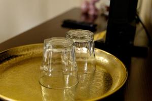 two glasses on a gold plate on a table at Green Garden Avrig in Avrig