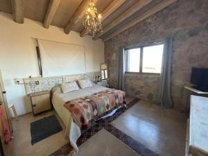 a bedroom with a bed and a window and a chandelier at Casita de ensueño Andes Crucecita in Las Compuertas