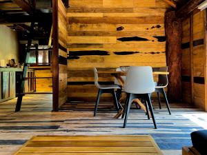una mesa y sillas en una habitación con paredes de madera en Treehouse Tulum H2Ojos en Tulum