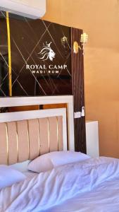 een slaapkamer met een bed met een bord aan de muur bij ROYAl WADI RUM CAMP in Wadi Rum