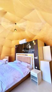 1 dormitorio con 1 cama grande en una habitación amarilla en ROYAl WADI RUM CAMP en Wadi Rum