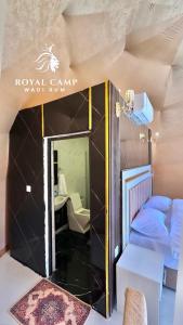 a small room with a bed and a mirror at ROYAl WADI RUM CAMP in Wadi Rum
