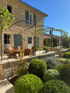 a patio with a table and chairs in front of a house at Les Oliviers De Notre Dame in Mazan