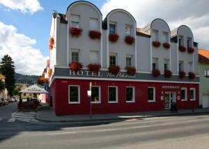 a hotel with a red and white building on a street at Hotel Na Pekárně in Sušice
