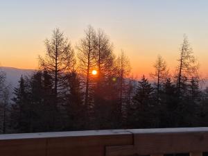 a sunset in the mountains with trees in the foreground at Almhütten Skorianz- Die Grüne Hirschhütte in Klippitztorl
