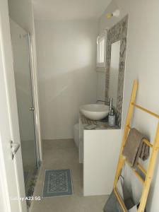 bagno con lavandino, servizi igienici e specchio di Casa Flavia a Torre Chianca