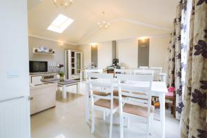 a kitchen and dining room with white tables and chairs at Green Garden Avrig in Avrig