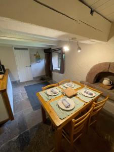 una mesa de madera en una cocina con mesa y sillas en La Hutte, en Tendon