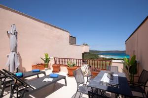Un patio con mesas y sillas en un balcón. en Harenae Beach Gataway by Wonderful Italy, en Porto Rotondo