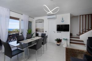 Un comedor y una sala de estar con mesa y sillas. en Harenae Beach Gataway by Wonderful Italy, en Porto Rotondo