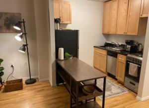 Il comprend une cuisine équipée d'une table et d'un réfrigérateur noir. dans l'établissement Cozy accommodation in Chelsea, à New York