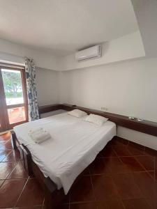a bedroom with a large white bed with a window at TAC - Açoteias Budget Studio in Olhos de Água +9 photos
