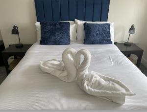two swans towels are sitting on a bed at The Norton- Hartlepool in Seaton Carew