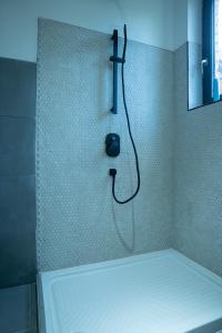una doccia con telefono appeso alla parete in bagno di Avantura Avala a Belgrado