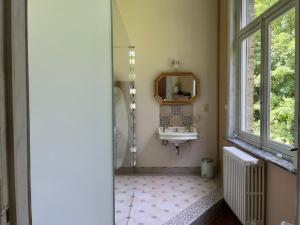 a bathroom with a sink and a mirror and a window at B&B Le Manoir de la Douve in Heuvelland