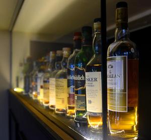 una fila de botellas de alcohol en un estante en The Tobermory Hotel en Tobermory